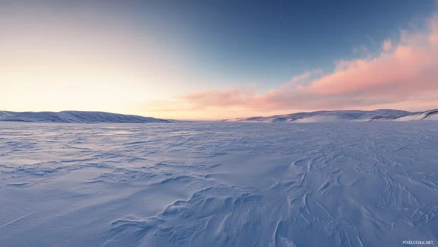 Vast snowy tundra stretching beneath pretty aurora sky.