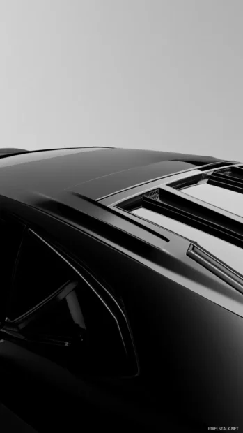Vertical angle showing the roof contours and spoiler of a black Lamborghini.