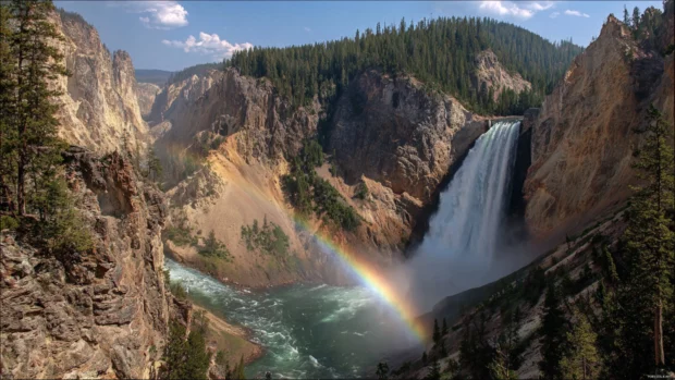 4k waterfall rainbow wallpaper capturing crystal clear water plunging into deep canyon pool with brilliant full rainbow across the mist.
