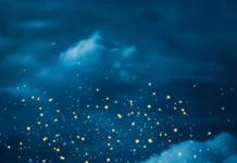 A book illuminated under fairy lights surrounded by gentle clouds.