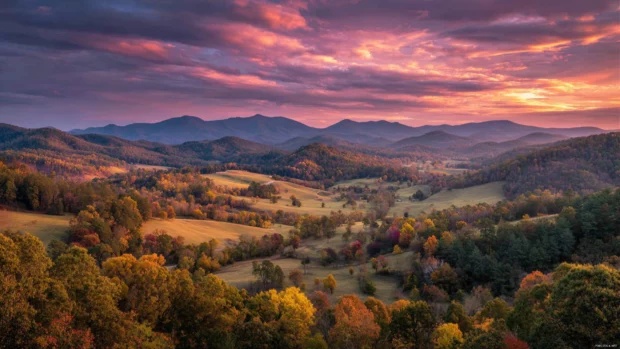 A glowing sunset casting golden hues over a sprawling fall landscape with layered forests and rolling hills.