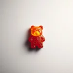 A gummy bear wallpaper featuring a single gummy bear centered on a white minimalist background.