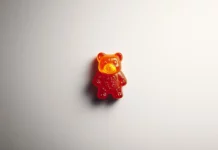 A gummy bear wallpaper featuring a single gummy bear centered on a white minimalist background.