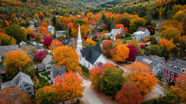 A picturesque village surrounded by colorful fall trees, each corner bursting with autumn life.