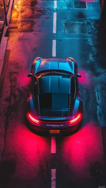 An overhead view of Porsche navigating tight city streets lit by glowing streetlights.