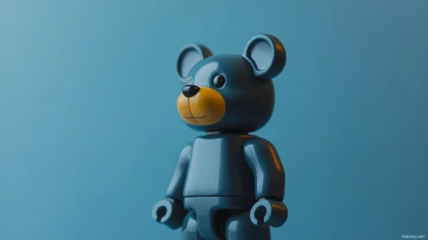 Bearbrick statue captured from side view in front of a muted blue canvas.