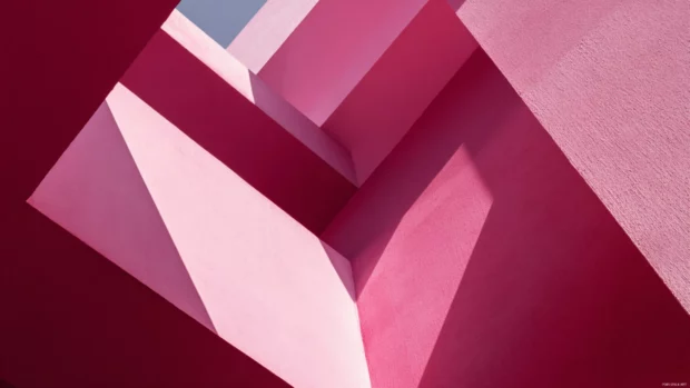 Bold pink geometric shapes with high contrast and abstract angles.