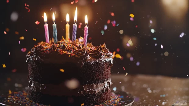 Chocolate birthday cake with colorful candles and confetti, perfect for a festive wallpaper.