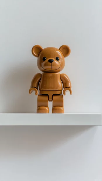 Decorative Bearbrick placed on white shelf with plain wall behind.