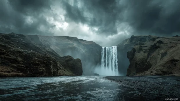 Dramatic waterfall desktop backgrounds showing powerful water gushing from towering cliffs under stormy skies.