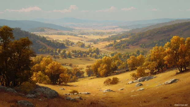 Fall landscape featuring a wide valley covered in golden trees under a soft afternoon sky.