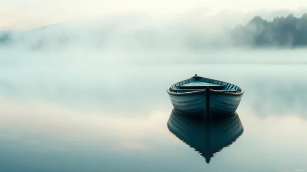 Fishing boat wallpaper 4K with mist rising around a small wooden boat anchored in still morning water.