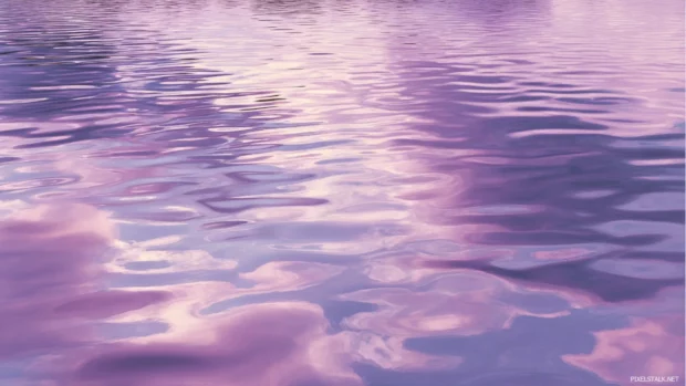 Gentle ripples on a lake surface reflecting sky painted in lavender color.