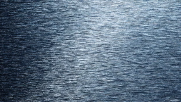 Luxury metal background portraying brushed titanium texture with fine grain and cool blue reflections.
