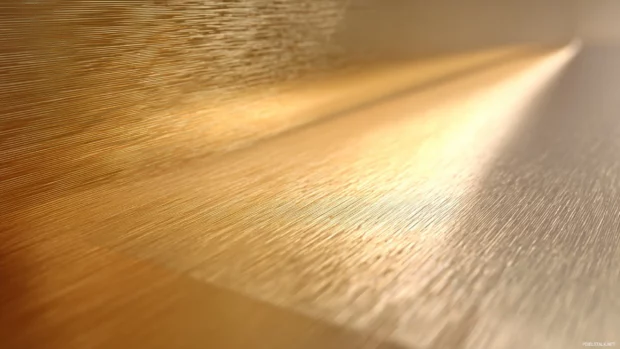 Luxury metal surface with brushed gold texture, soft lighting and subtle reflections.