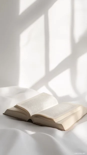 Minimalist book lover wallpaper with a single open novel, clear background, and gentle morning light.