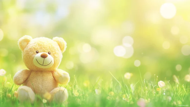 Smiling Teddy Bear standing on grass, blurred simple background.