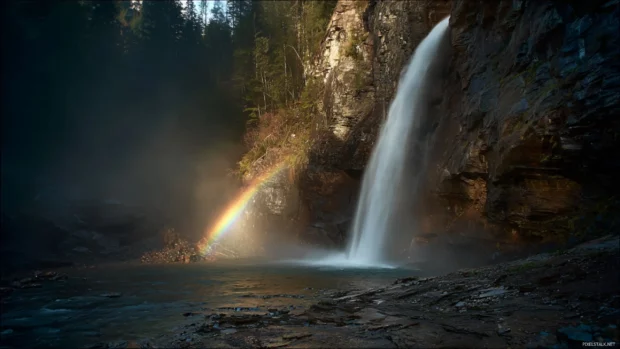 The Waterfall glows in the morning light as a delicate rainbow forms in the spray.