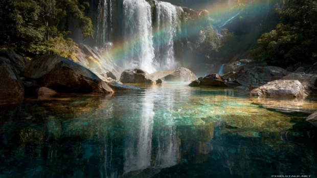 Waterfall crashing into a crystal clear pool with a vivid rainbow appearing in the background (2).