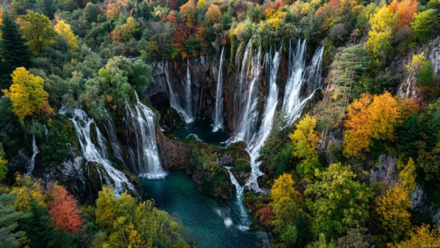 Waterfall landscape 4k wallpaper presenting aerial vista of multiple tiered waterfalls running through vivid forest canyon.