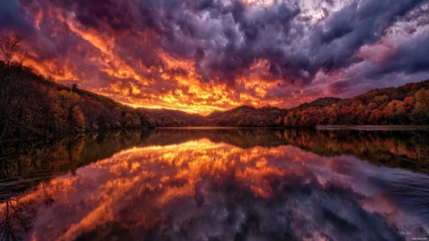 4k foliage wallpaper HDR style depicting dramatic sky above fiery forest hills reflecting into calm reservoir.