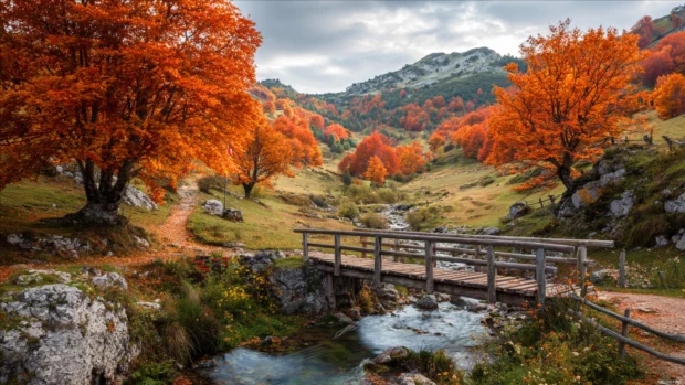 A scenic autumn landscape unfolds with vibrant orange and red trees beside an old wooden bridge crossing a stream.