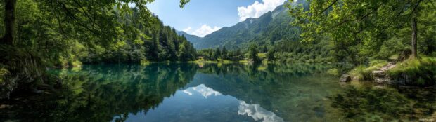 A serene view of a tranquil mountain lake surrounded by lush forests, perfectly spanning across three screens.