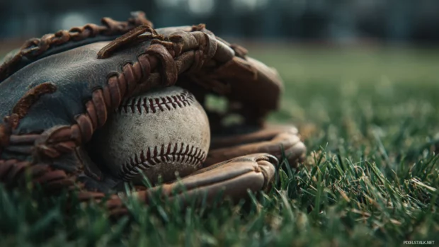 Baseball wallpaper 4k capturing a dramatic close up of leather glove and ball on outfield grass.