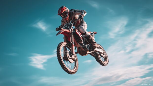 Best free HD dirt bike wallpapers highlighting a rider performing a jump against a blue sky.