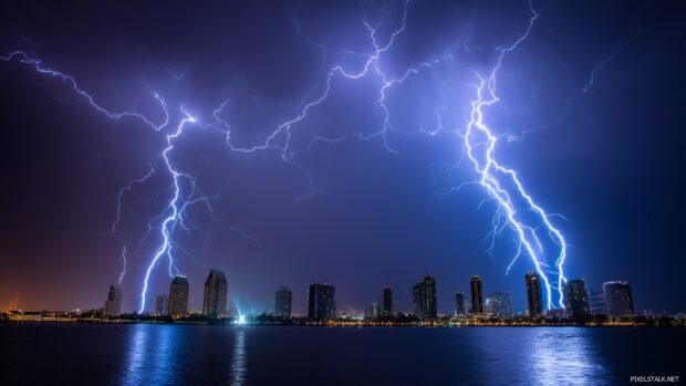 Dramatic lightning storm visuals, A vibrant display of multiple lightning strikes illuminating a city skyline during a fierce storm.
