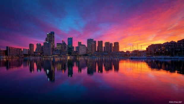 Free high resolution wallpaper hd showcasing a vibrant city skyline at sunset with colorful reflections on the water.