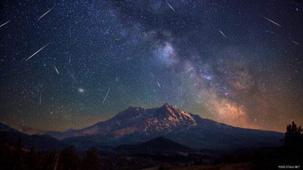 Free starry night wallpapers hd with shooting stars and a majestic mountain backdrop.
