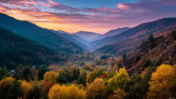 Golden mountains glowing under the Beautiful Autumn sky with colorful trees lining the valley below.