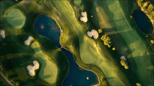 Golf course wallpapers, An aerial view of a golf course with strategically placed bunkers and water hazards under a bright sun.