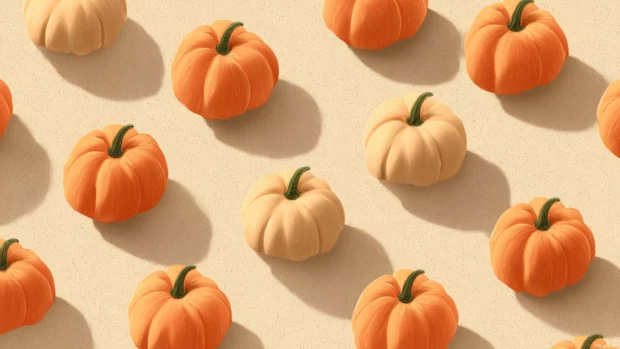 Pumpkin background wallpaper showing tiny pumpkins aligned in grid style over a creamy pastel background with shadowed edges.
