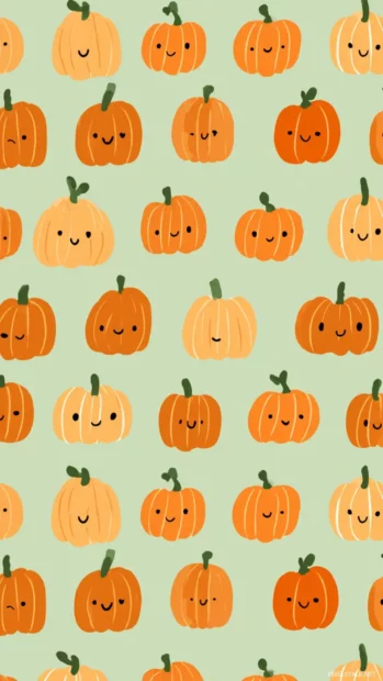 Pumpkin pattern wallpaper designed with small pumpkins and smiling faces in symmetrical rows and soft pastel greens.