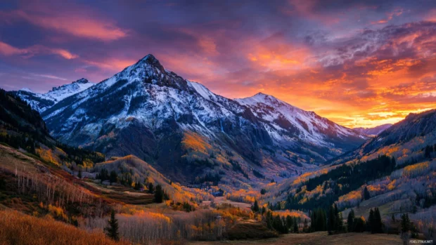 Sunrise fall mountain wallpaper capturing dawn light cresting over autumn‑covered mountain valley.