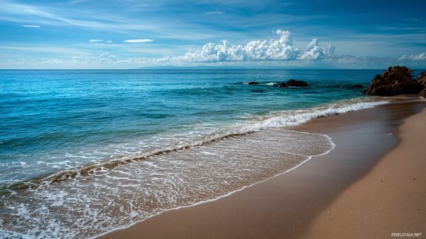 Very cool backgrounds hd illustrating a peaceful beach scene with gentle waves lapping at the shore.