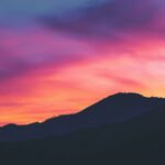 Vibrant laptop wallpapers featuring a sunset over a mountain ran