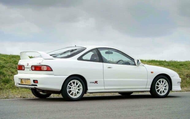 A white Honda Integra Type R is parked on a road beside grassy terrain under a cloudy sky, HD Desktop Wallpaper