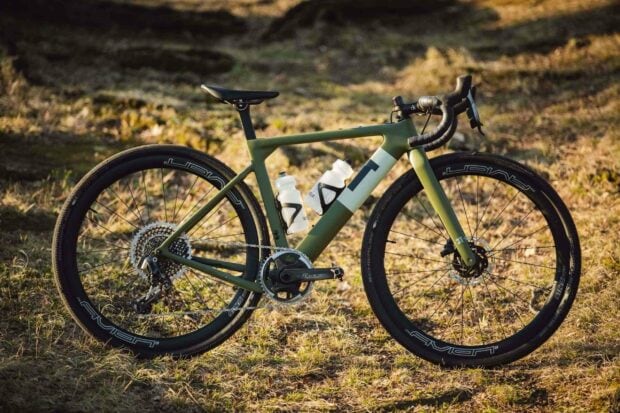 A 3T bike stands on dry grass with two water bottles attached, 2K Desktop Wallpaper