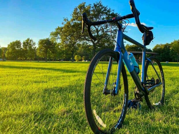A 3T bike is parked on green grass in a sunny park with trees in the background, HD Desktop Wallpaper