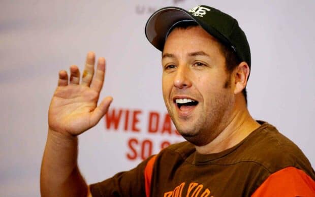 Adam Sandler smiles and waves with a baseball cap on, 2K Desktop Wallpaper