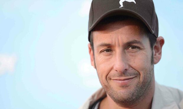 A close up portrait of Adam Sandler wearing a cap and smiling against a clear sky, 2K Desktop Wallpaper