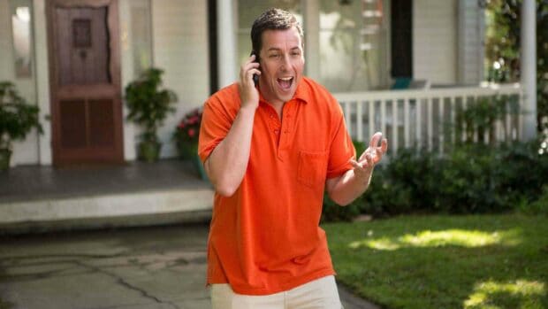 Adam Sandler is talking on the phone outside a house wearing an orange shirt, 2K Desktop Wallpaper