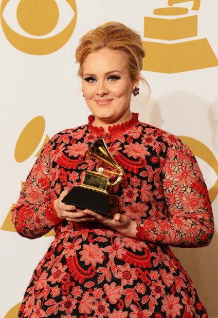 Adele is smiling while holding a Grammy award at an event, 2K Phone Wallpaper