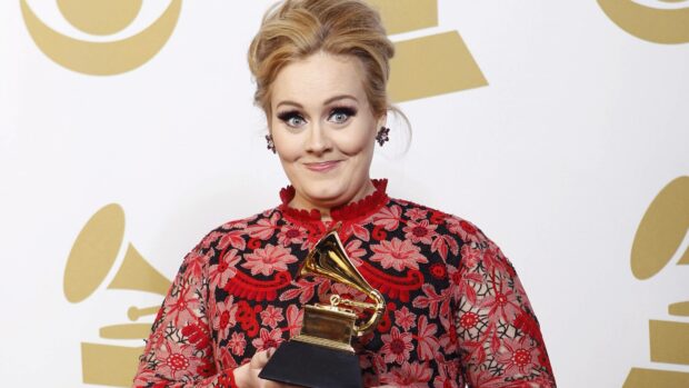 Adele is holding a Grammy award at the ceremony with a proud expression, 4K Desktop Wallpaper