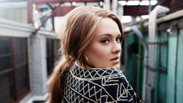 A portrait of Adele wearing a stylish embroidered jacket while looking over her shoulder, HD Desktop Wallpaper