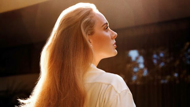 Adele looks contemplatively into the distance with warm backlight highlighting her hair, 4K Desktop Wallpaper