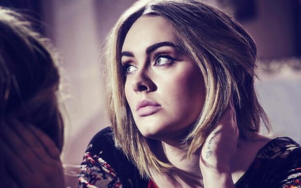 A close up portrait of Adele looking thoughtfully to the side with soft lighting, 2K Desktop Wallpaper